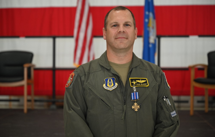 Mike "Vago" Hilkert standing in front of the American flag