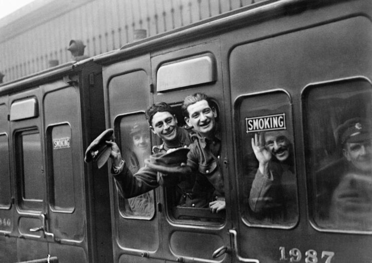 Soldiers waving out of a train window