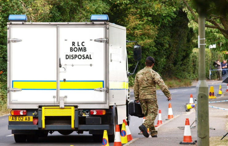 Bomb squad member walking beside a truck