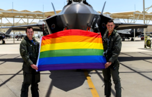 Maj. Tyler McBride and Capt. Justin Lennon holding the Pride Flag