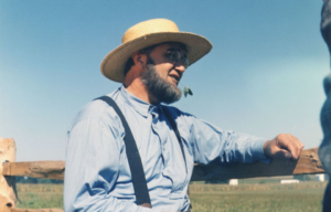 Amish man standing at the side of a field