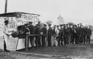 British soldiers lining up outside of a fish and chips stand