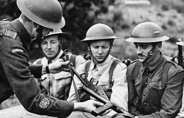 Sgt. Maj. E.H. Chevrier instructs Canadian Army recruits on the use of the STEN Mk II