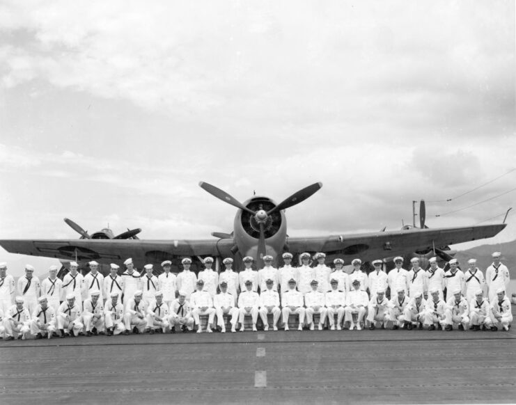 Crew of the USS San Jacinto (CVL-30) standing in front of a bomber on the flight deck of the light aircraft carrier