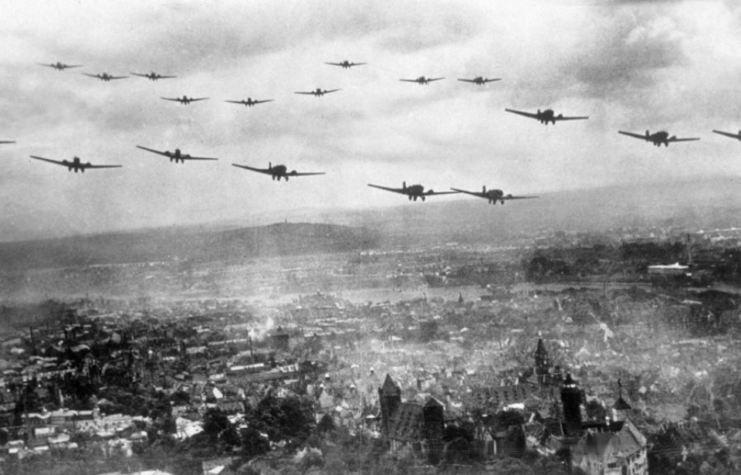 WWII-era German aircraft flying over a destroyed city