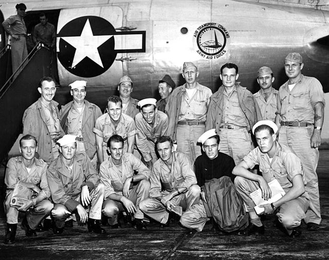 Group of US Navy sailors standing in front of an aircraft