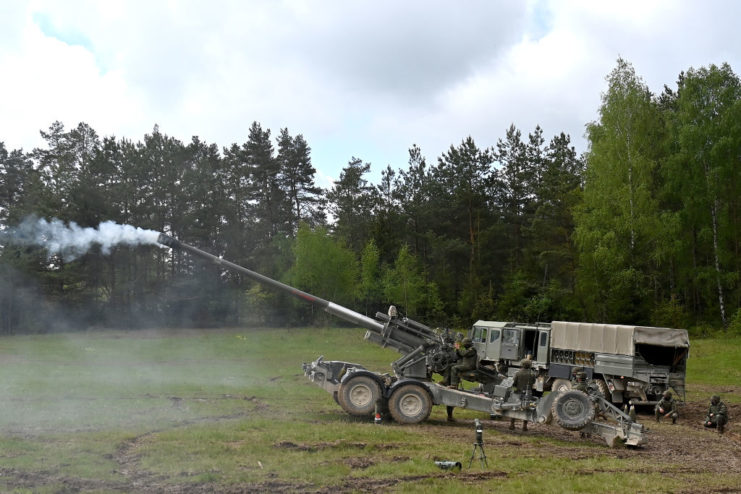 Spanish soldiers firing an M777 howitzer