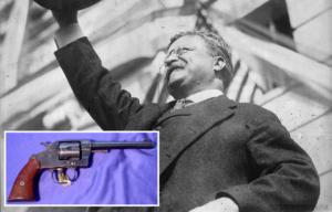 Theodore Roosevelt holding up his hat + Colt M1892 revolver on a purple sheet