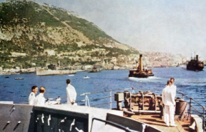 Naval officers standing on the deck of a ship that's docked off the coast of Gibraltar