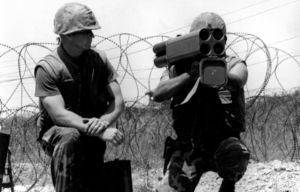 US Marine aiming an M202 FLASH while another kneels beside him