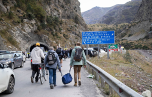 Citizens fleeing Russia's mobilization efforts walk toward a customs checkpoint at the Russian-Georgian border