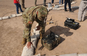 American soldier standing beside an XM204 top attack munition unit