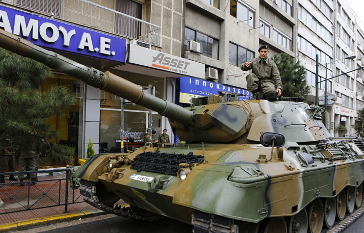 Greek soldier crouching atop a Leopard I