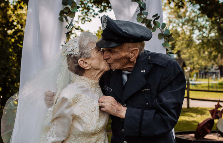 Royce and Frankie King kissing under a veiled arch