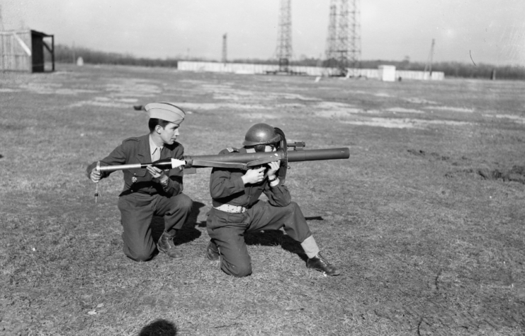 Soldier aiming an LRAC-50 73 mm bazooka while another loads a rocket into it