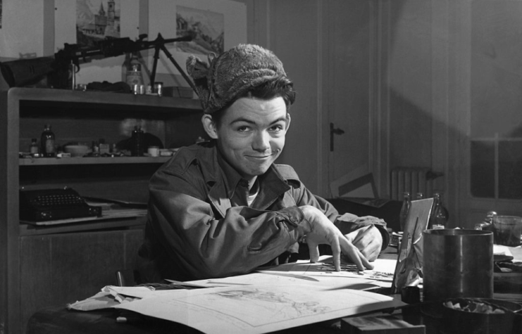 Bill Mauldin sitting at a desk