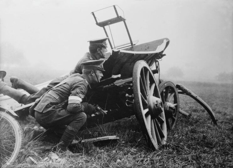 Two British dispatch riders crouching behind a vehicle