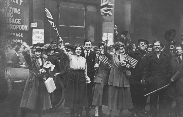 Crowd waving British flags along a street