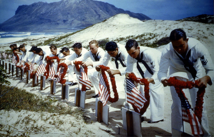 US Navy sailors placing leis on the graves of fallen servicemen