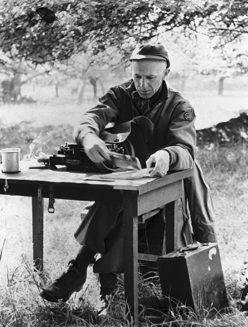 Ernie Pyle working at a desk outdoors