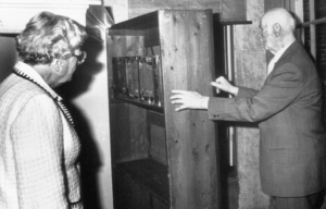 Otto Frank opening a bookcase door in front of Queen Juliana of the Netherlands