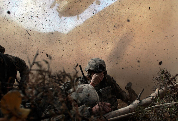 US Army soldiers shielding their eyes from sand and debris