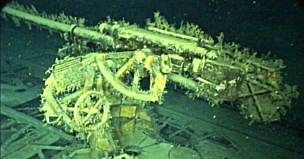 U-166's deck gun covered in algae on the ocean floor