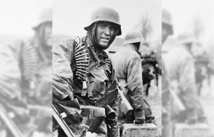 Hans Tragarsky standing in uniform, with an ammunition belt around his shoulders