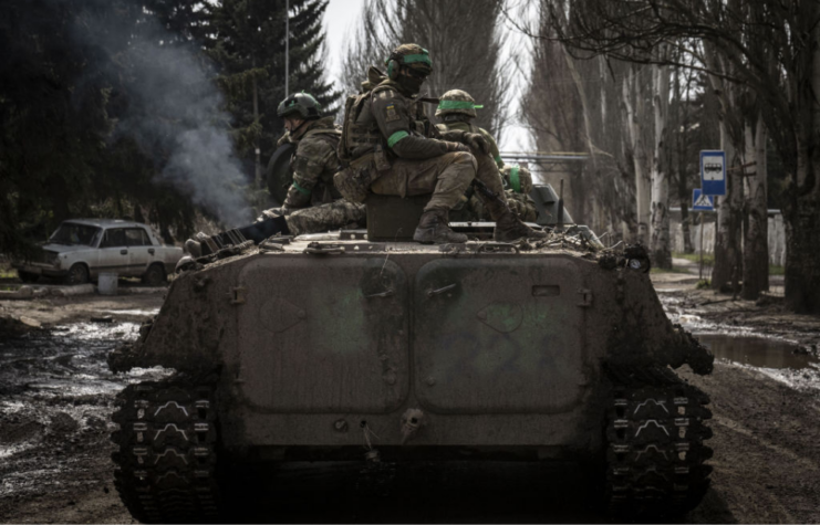 Ukrainian troops manning a tank in the middle of a street