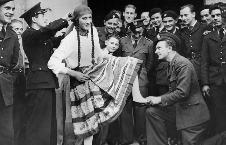 Polish airman dressed in drag while other aviators stand around him