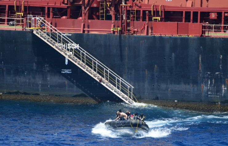 Assault boat filled with people moving away from the MV Ruen