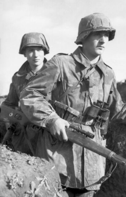 Two members of the Luftwaffe's Field Division walking through a trench