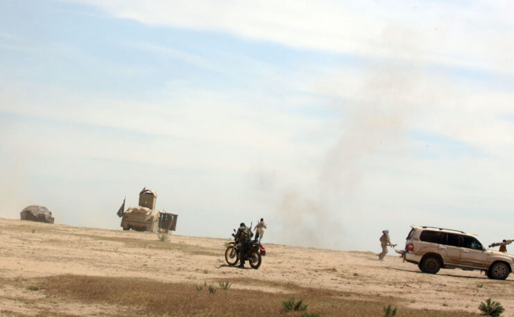 Abu Tahsin al-Salhi sitting on a motorcycle in the middle of the desert