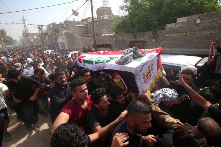 Mourners carrying the casket of Abu Tahsin al-Salhi down a street