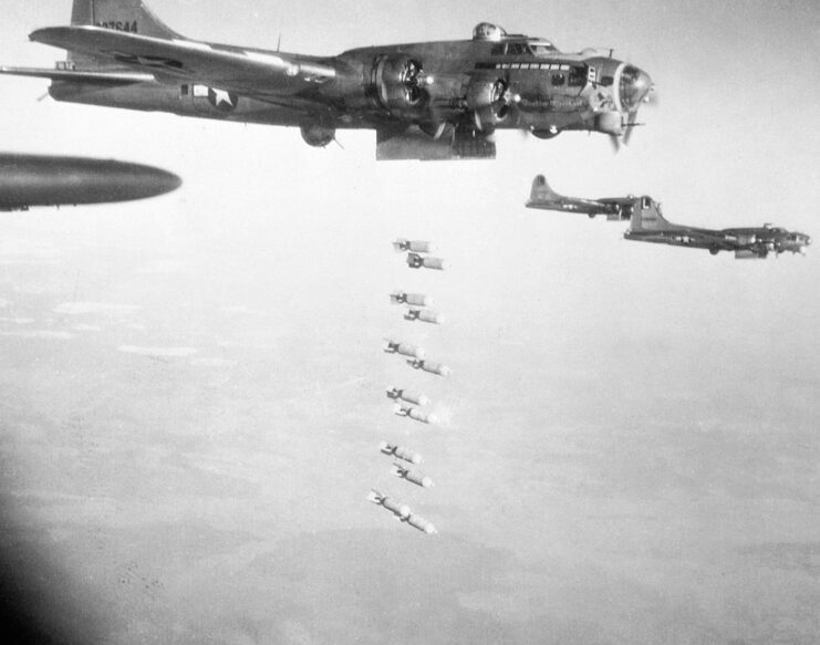 Boeing B-17 Flying Fortress dropping bombs, while three others fly around it