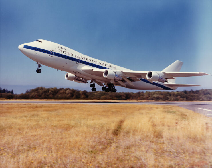 Left side of Boeing E-4A taking off of runway. 