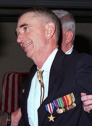 Carlos Hathcock wearing a silver star and black suit. 