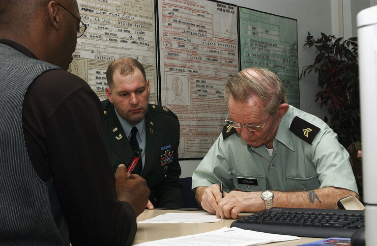 James Culp sitting with Charles Robert Jenkins as he writes at a desk