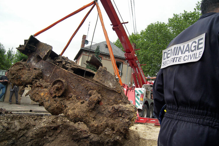 Mechanical digger lifting an M5 Stuart from a hole in the ground