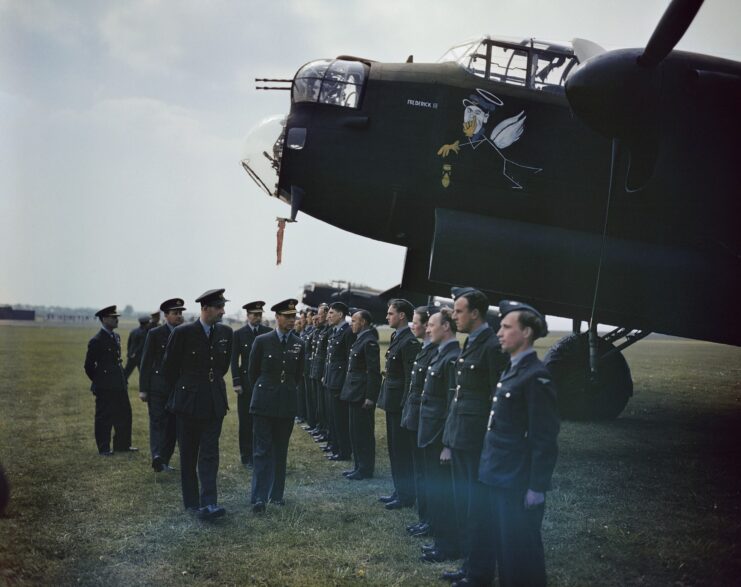 King George VI and other officials walking before members of the No. 617 Squadron RAF