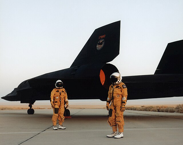Two crewmen standing next to a Lockheed SR-71 on the tarmac