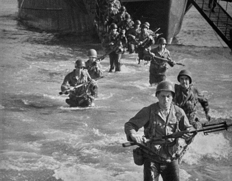 American troops wading through water after exiting a landing craft