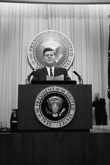 John F. Kennedy speaking at a podium