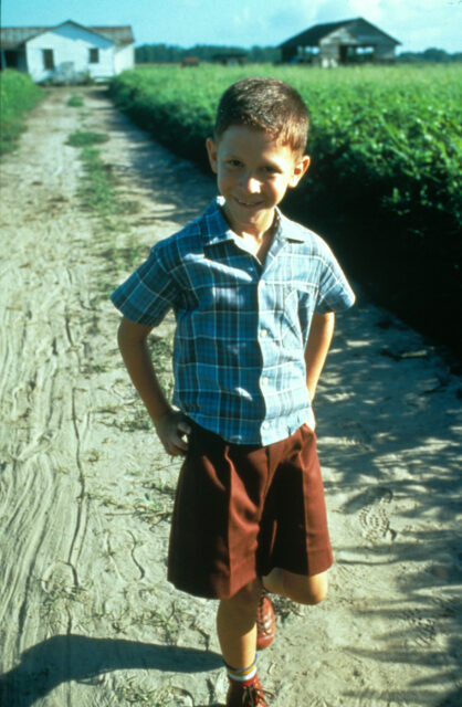 Young Humphreys standing on a dirt road leading to a house on the set of 'Forrest Gump."