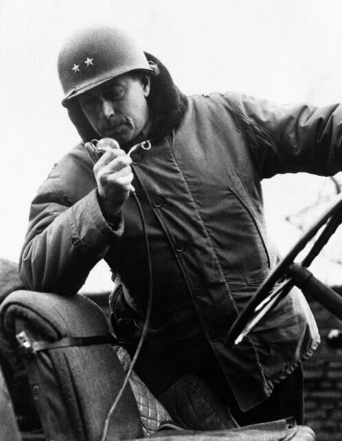 Maurice Rose talking on the radio while sitting in a Jeep