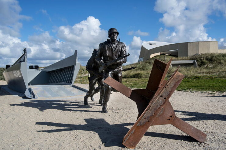 Memorial featuring statues of two soldiers running from a landing craft toward a Czech Hedgehog
