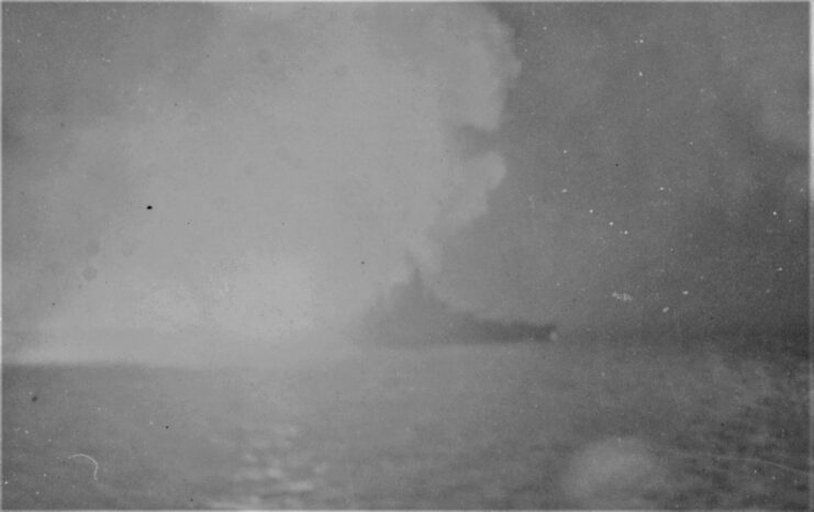 USS West Virginia (BB-48) shrouded in smoke at sea