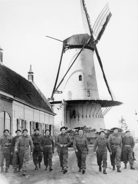 Troops of the 1st Polish Armoured Division passing a Dutch windmill. 