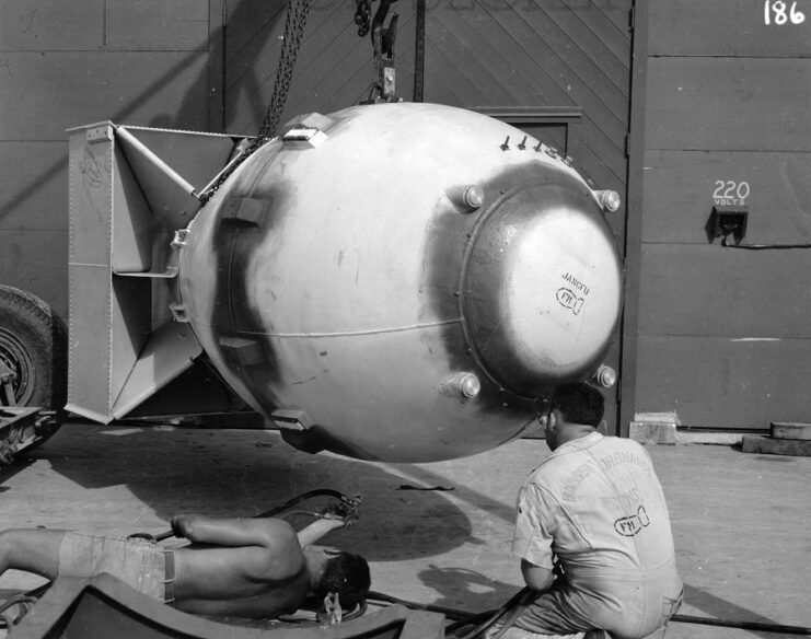 Two men examining the atomic bomb 'Fat Man'