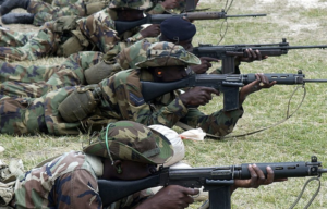 Jamaican soldiers aiming FN FALs while lying on the ground